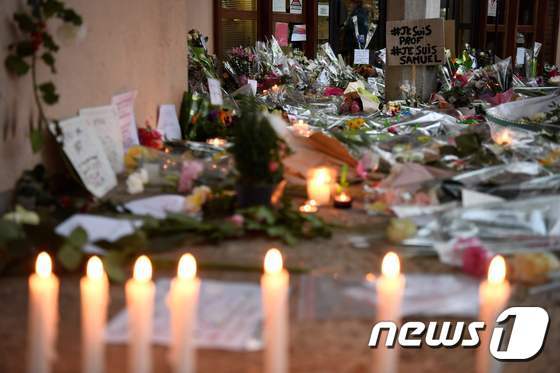 참수된 채 발견된 프랑스 교사 사뮤엘 프티가 재직하던 중학교에 그를 추모하는 촛불과 꽃이 놓여있다. © AFP=뉴스1
