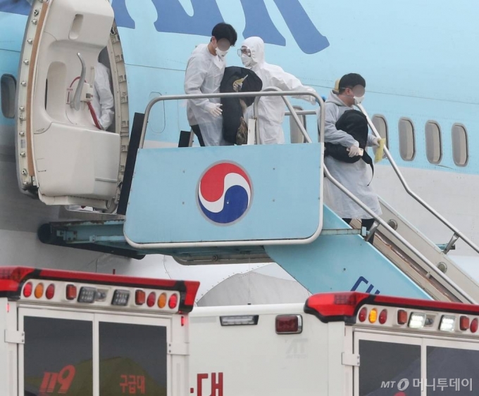 지난 2월 신종 코로나 바이러스 감염병 발원지인 중국 후베이성 우한시에 남아있던 우리 교민들이 두 번째 전세기를 타고 1일 오전 김포공항에 도착, 비행기에서 내려 차량으로 향하고 있다.