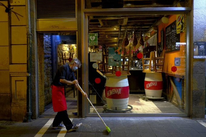 21일(현지시간) 스페인 북부 팜플로나에서 코로나19 새 규제에 따라 모든 술집과 식당이 향후 2주간 오후 11시부터 문을 닫게되면서 한 남성이 술집 문을 닫을 준비를 하고 있다./사진=[팜플로나=AP/뉴시스]