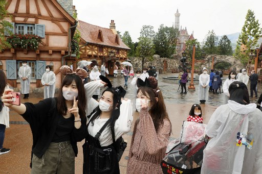 지난 9월 28일 일본 도쿄 디즈니랜드에서 마스크를 낀 입장객들이 사진을 찍고 있다./사진=AFP