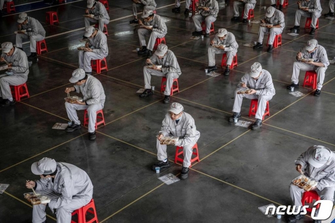 코로나19 발원지로 지목되는 후베이성 우한의 동펑 혼다 자동차 공장 조립라인에서 종업원들이 점심을 먹고 있다.  /AFP=뉴스1