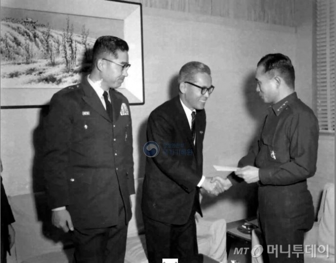 박정희 국가재건최고회의 의장(오른쪽)이 1962년 12월 22일 이병철 삼성물산 사장(중앙)으로부터 5.16장학금 1000만원을 기증받고 악수를 나누고 있다./사진제공=행정안전부 국가기록원