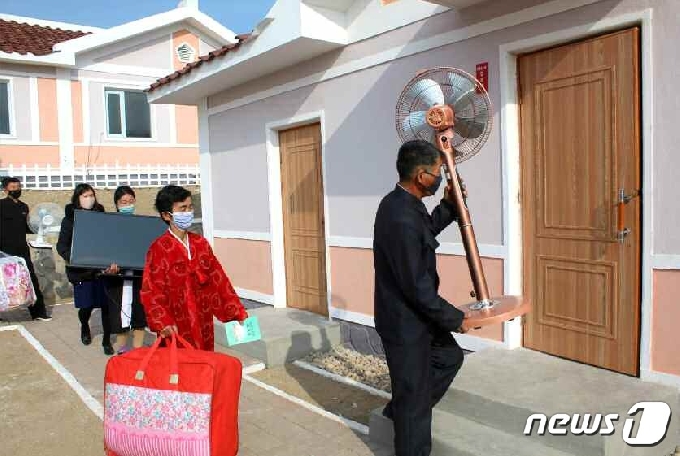[사진] 수해 복구 후 얻은 새 집에 들어가는 북한 주민들