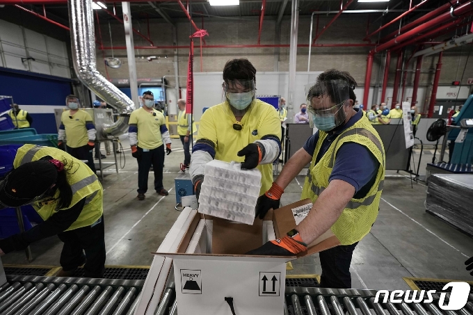 미국 제약사 화이자 직원들이 13일(현지시간) 미시간주 캘러마주 공장에서 코로나19 백신을 운반용 냉동상자에 담고 있다. © AFP=뉴스1