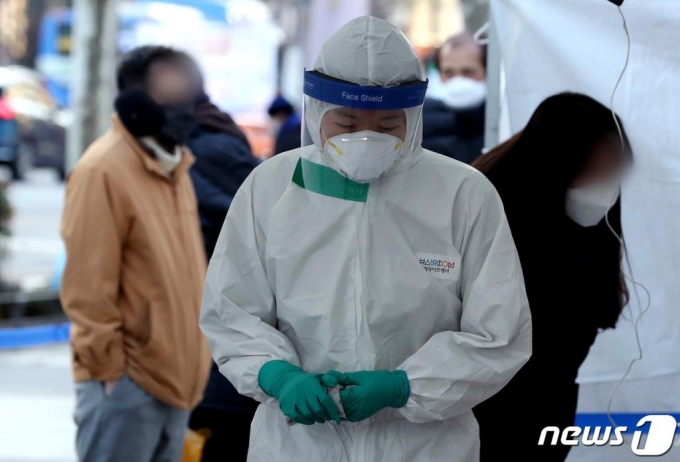 지난 14일 서울 종로구 탑골공원 앞에 마련된 신종 코로나바이러스 감염증(코로나19) 임시 선별진료소에서 의료진이 핫팩으로 손을 녹이고 있다./사진=뉴스1
