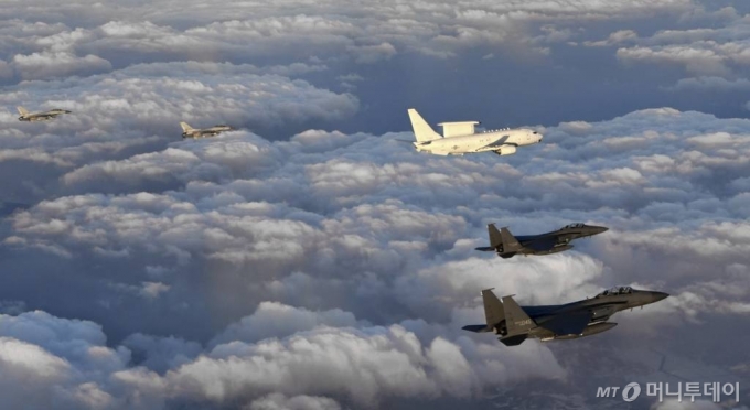 [서울=뉴시스]문재인 대통령이 탑승해 지휘비행 중인 공군 항공통제기 E-737기가 F-15K, F-16 전투기 편대의 호위를 받으며 상공을 비행하고 있다. (사진=합참 제공) 2021.01.01. photo@newsis.com