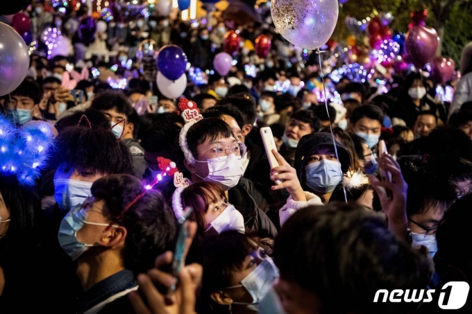 (우한 AFP=뉴스1) 우동명 기자 = 31일(현지시간) 코로나19 진원지인 중국 후베이성 우한에서 새해 카운트다운 행사에 참석한 마스크를 쓴 시민들이 붐비고 있다.   ⓒ AFP=뉴스1  