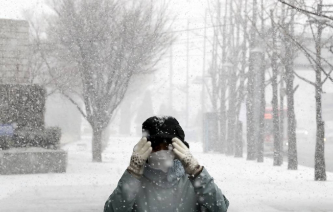 서울에 눈이 내리고 있는 18일 오전 서울 종로구 거리에서 시민이 내리는 눈을 맞으며 발걸음을 재촉하고 있다./사진=뉴시스
