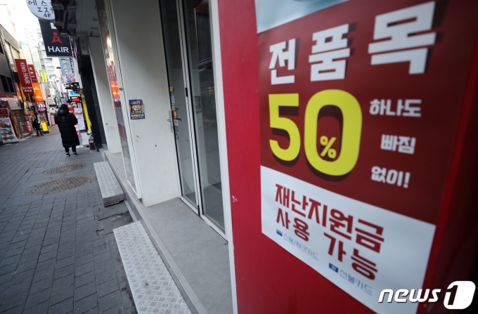 정부가 거리두기 단계(수도권 2.5단계·비수도권 2단계)를 2주간 연장하기로 한 16일 서울 중구 명동 거리의 한 가게에 재난지원금 사용 가능 안내문이 붙어 있다. /사진=뉴스1