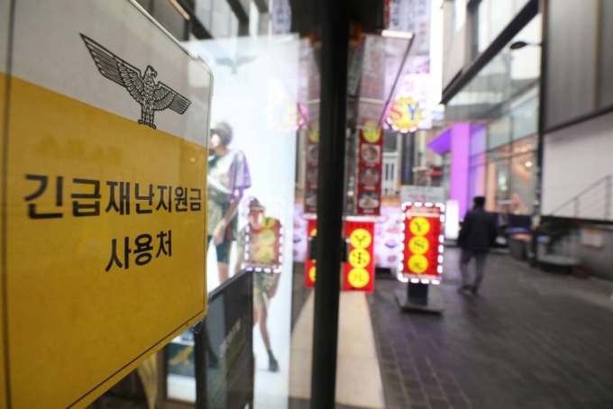 서울 중구 명동의 한 상점에 긴급재난지원금 사용 가능 안내문이 붙어있다. / 사진=뉴시스