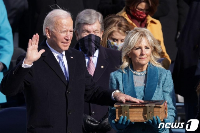 조 바이든 제46대 미국 대통령이 부인 질 바이든 여사와 함께 20일 정오(현지시간) 미연방의사당 앞에서 취임선서를 하고 있다. ⓒ AFP=뉴스1