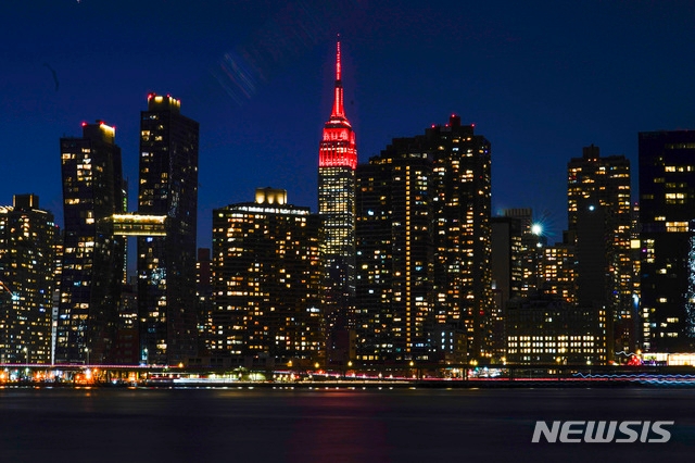 뉴욕=AP뉴시스/ 19일(현지시간) 미국 뉴욕의 엠파이어 스테이트 빌딩 꼭대기에 코로나19 희생자를 추모하는 붉은색 조명이 켜져 있다. 2021.01.20.