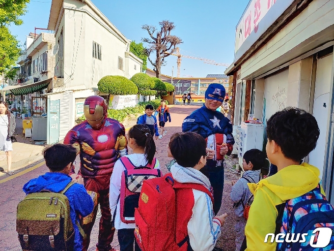 광주 남구 대촌중앙초등학교 학생들이 등교길에 영화 속 히어로인 캡틴 아메리카와 아이언맨을 만나 사탕을 받고 있다.(광주시교육청 제공) 2019.5.4/뉴스1 © News1