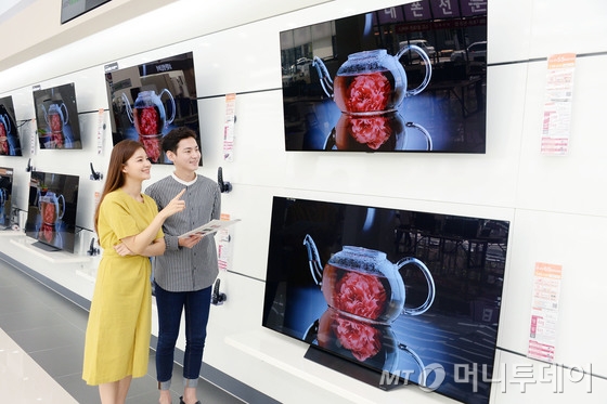 2018년 5월 서울 영등포구 LG 베스트샵 매장에서 모델들이 'LG 올레드 TV'를 살펴보고 있다.(LG전자 제공)/사진=뉴스1