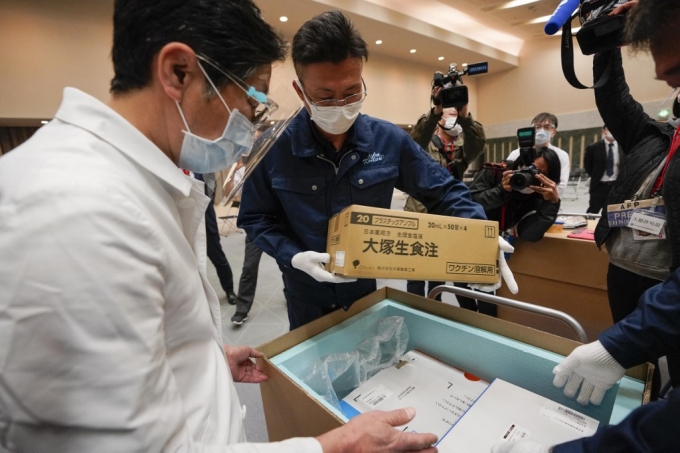 지난 16일 일본 도쿄의 한 병원에서 직원과 배달원이 병원에 전달된 화이자-바이오엔테크 코로나19 백신의 포장 및 운송 상태를 점검하고 있다./사진=AFP