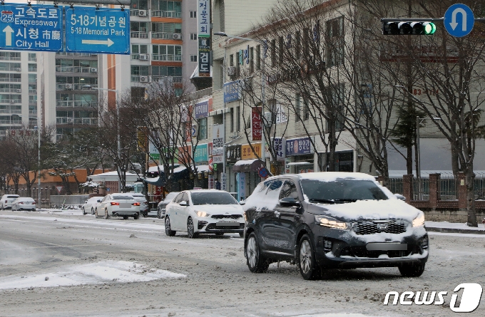 광주와 전남에 사흘째 눈이 내리고 있는 가운데 18일 오전 광주 서구 치평동 한 도로에서 차량들이 감속 운행하고 있다. 2021.2.18/뉴스1 © News1 이수민 기자