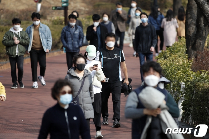 서울 낮 최고기온이 12도로 예보된 22일 오후 서울 송파구 석촌호수에서 시민들이 산책을 하고 있다. 2021.2.22/뉴스1 © News1 이승배 기자