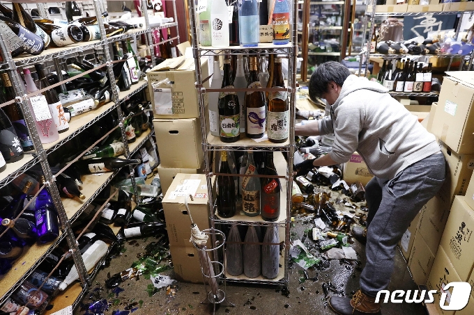 지난 13일 일본 후쿠시마의 한 술집에서 직원이 지진으로 깨진 병을 정리하고 있다. 지난 13일 밤 일본 후쿠시마 등에서 발생한 지진은 규모 7.3으로 이로 인한 쓰나미는 없었으나 그후 진도 1~4에 이르는 다수의 지진이 잇따르고 있다. © 로이터=뉴스1