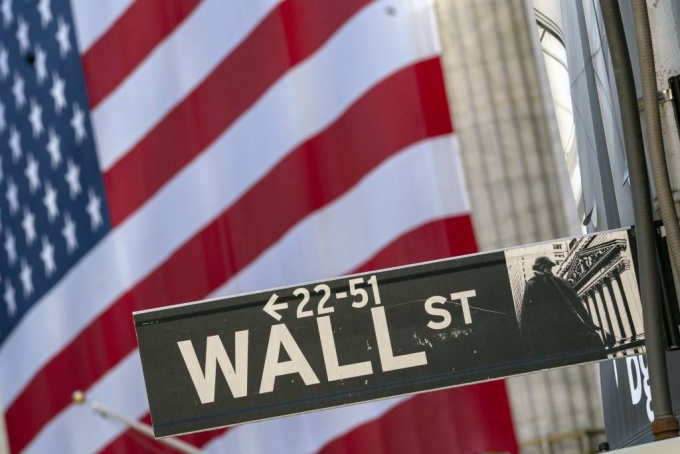 FILE - In this Monday, Sept. 21, 2020, file photo, a Wall Street street sign is framed by a giant American flag hanging on the New York Stock Exchange in New York. Stocks are falling in early trading on Wall Street Monday, Oct. 26, 2020, and deepening last week’s losses. (AP Photo/Mary Altaffer, File) / 사진제공=AP 뉴시스