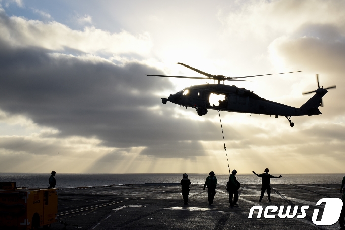 태평양 지역으로 이동하기 위해 미국 샌디에이고 기지를 떠난 미 핵추진 항공모함 시어도어 루스벨트호에서 MH-60S 시호크 헬기가 보급 화물을 내리고 있다. (미 해군) 2017.10.10/뉴스1