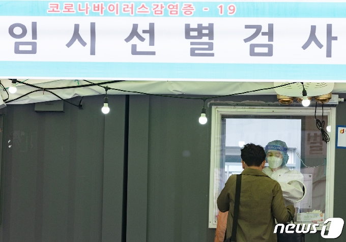 13일 서울 중구 서울역 광장에 마련된 임시 선별검사소를 찾은 시민이 검체검사를 받고 있다. 2021.4.13/뉴스1 © News1 이재명 기자