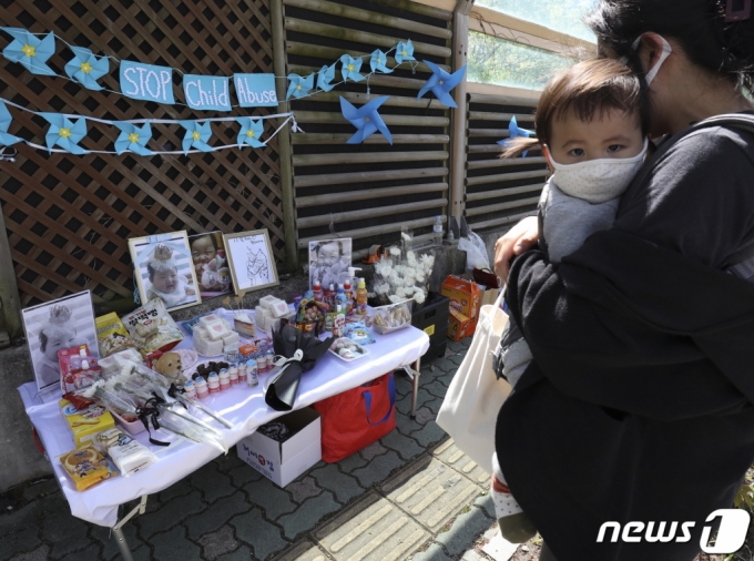 지난 14일 오후 울산 남구 울산지방법원 앞에서 16개월 여아 '정인이' 제사상이 차려진 가운데 한 시민이 아기를 안고 추모하고 있다. /사진=뉴스1