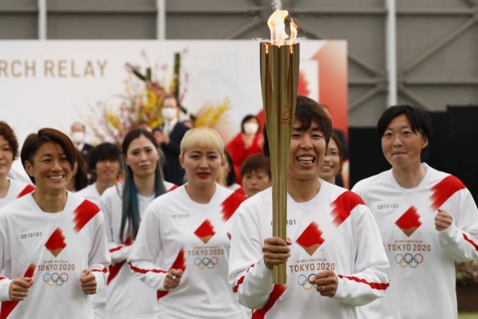 25일 일본 후쿠시마현 나라하에서 2020 도쿄올림픽 성화 봉송이 시작돼 2011년 당시 일본 여자축구 국가대표팀 '나데시코 재팬' 구성원들이 성화 봉송을 하고 있다. 성화 봉송은 도쿄올림픽 개막식이 열리는 7월23일까지 121일 동안 일본 전역을 돌면서 진행된다. 2021.03.25./사진=[나라하=AP/뉴시스]