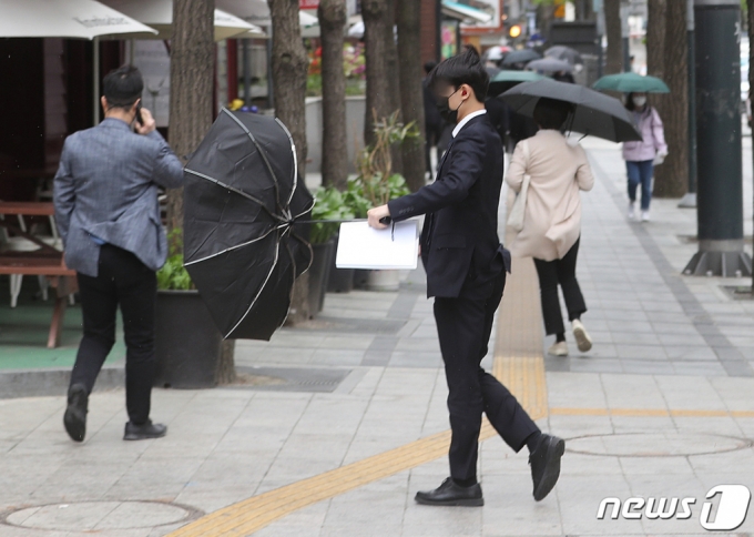 봄비가 내린 지난 12일 서울 청계천 일대에서 한 시민의 우산이 바람에 뒤집어지고 있다. /사진=뉴스1