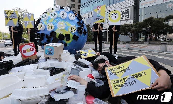 [사진] 배달용 쓰레기에 드러누운 환경단체 활동가들