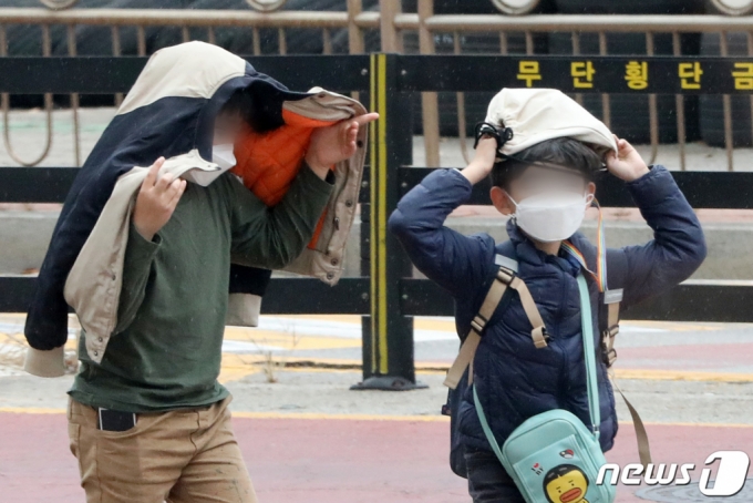 지난해 11월17일 오후 경기도 오산시내에서 초등학생들이 소나기가 내리자 옷과 가방을 머리에 쓴 채 비를 피하고 있다. /사진=뉴스1