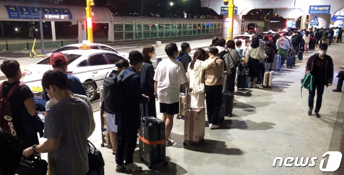 지난 25일 오후 9시45분쯤 제주국제공항 택시승강장에서 관광객들이 차량을 기다리고 있다. 저녁 늦은 시간에도 관광객이 붐비며 거리두기가 지켜지지 않는 모습이다. /사진=뉴스1