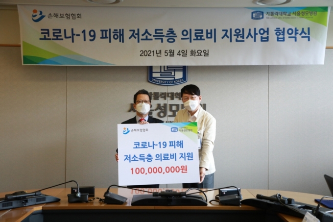 정지원 손해보험협회장(왼쪽)이 김용식 서울성모병원장(오른쪽)에게 의료비 지원금을 전달하고 있다./사진=손해보험협회