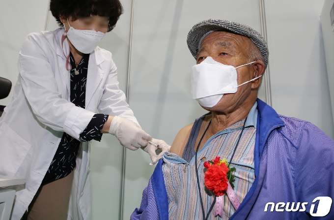 7일 오후 대전 유성구 예방접종센터에서 한 어르신이 카네이션을 달고 화이자 백신을 접종받고 있다. 2021.5.7/뉴스1 © News1 김기태 기자