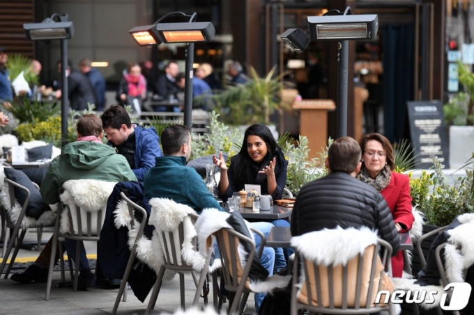 (런던 AFP=뉴스1) 우동명 기자 = 29일(현지시간) 런던의 점심시간 레스토랑 야외 테이블에서 시민들이 마스크를 벗고 식사를 하고 있다.  (C) AFP=뉴스1  