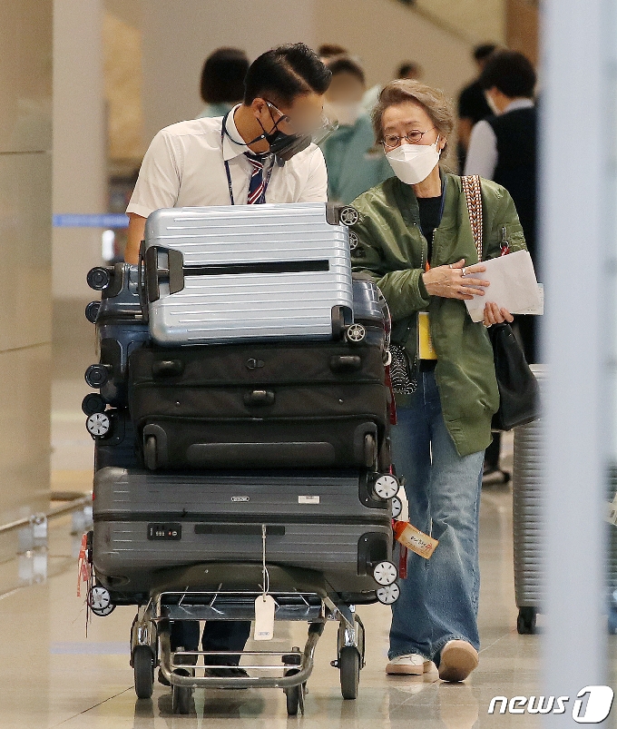 수많은 짐으로 인해 공항 직원의 도움을 받으며 입국하는 윤여정. 2021.5.8/뉴스1 © News1 김진환 기자