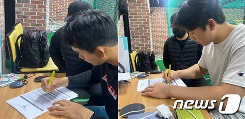 MLB 신분조회 및 등록 서류에 서명하고 있는 김선동 선수(왼쪽)와 김유신 선수 © 뉴스1