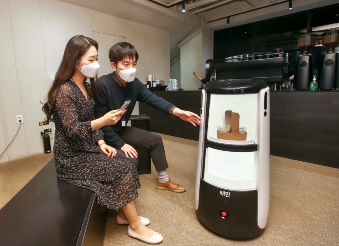 D타워 광화문에서 배달로봇 딜리타워를 이용해 커피 배달 서비스를 시연하고 있다./사진제공=DL이앤씨