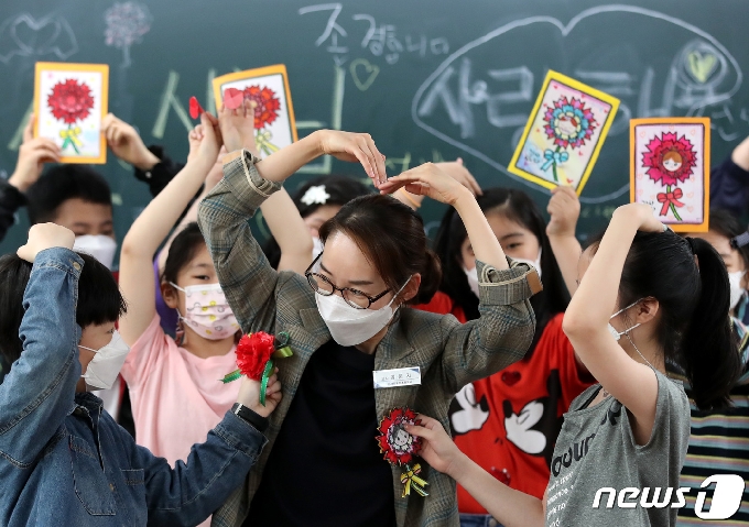 스승의 날을 하루 앞두고 14일  대전 한 초등학교에서 교사가 학생들에게 카네이션을 받고 있다. 2021.5.14/뉴스1 © News1 김기태 기자