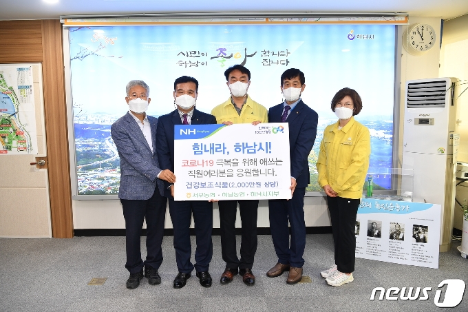 하남시 농협관계자들이 김상호 시장(가운데)에게 코로나19 의료진을 위한 2000만원 상당의 건강보조식품을 전달하고 있다.(농협측 제공) © News1