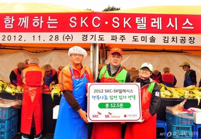 최신원 SKC회장(오른쪽)이 2012년 11월 28일 경기도 파주에서 임직원들과 함께 김장김치를 담그고 있다./사진제공=SKC
