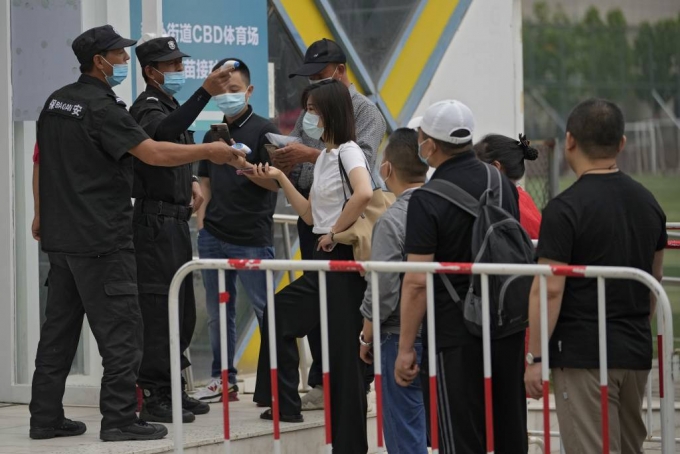  [베이징=AP/뉴시스]2일 중국 베이징에서 코로나19 확산을 막기 위해 마스크를 쓴 시민들이 중국의약집단 시노팜 백신을 접종하기 위해 줄 서 있다. 