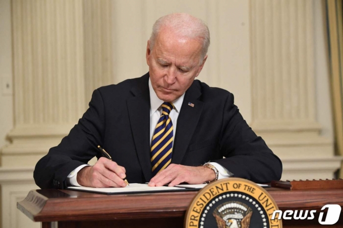 (워싱턴 AFP=뉴스1) 우동명 기자 = 조 바이든 미국 대통령이 24일(현지시간) 워싱턴 백악관에서 반도체· 희토류 ·배터리 등 핵심 품목의 공급망을 확보하는 내용의 행정명령에 서명을 하고 있다.   (C) AFP=뉴스1  