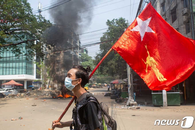 2021년 3월 27일 쿠데타가 한창인 미얀마 양곤에서 한 남성이 민주주의민족동맹(NLD) 깃발을 들며 항의 운동을 벌이고 있다. © 로이터=뉴스1 © News1 정윤영 기자