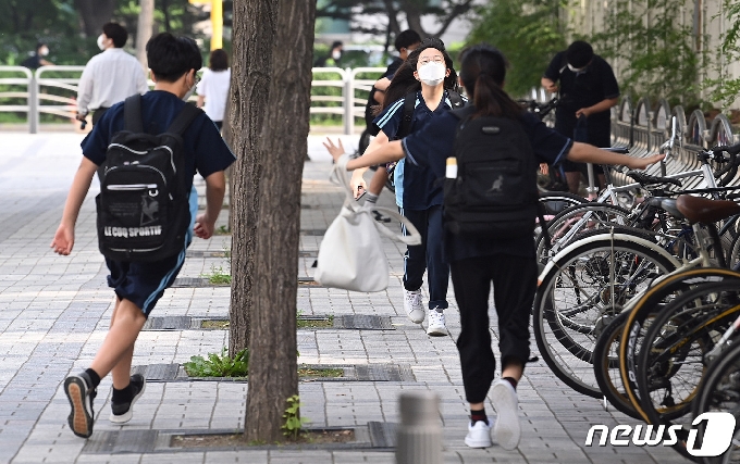 수도권 중학교의 등교 수업이 확대된 지난 14일 서울 한 중학교에서 학생들이 친구들과 반갑게 인사를 나누며 등교하고 있다. /뉴스1 © News1 사진공동취재단