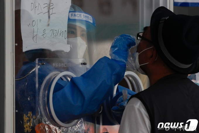 지난 14일 오전 서울역에 마련된 중구임시선별진료소에서 의료진이 검체채취를 하고 있다. /사진제공=뉴스1