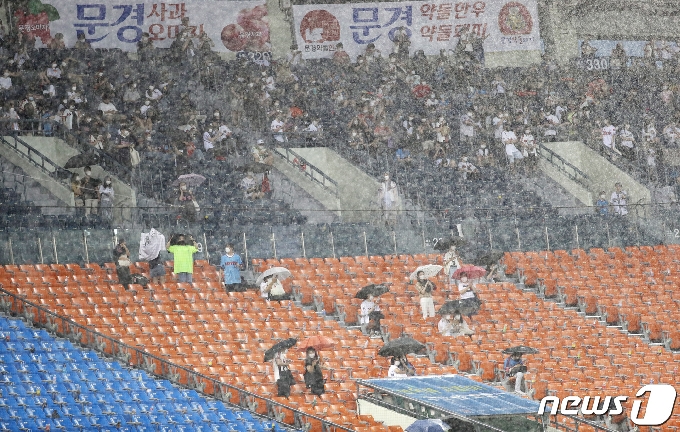[사진] 우천 중단에 우산쓰고 대기하는 시민들