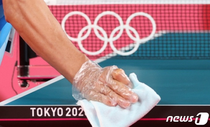 (도쿄=뉴스1) 송원영 기자 = 2020 도쿄 올림픽을 3일 앞둔 20일 일본 도쿄체육관에서 올림픽 관계자가 신종 코로나바이러스 감염증(코로나19) 확산 방지를 위해 탁구대를 소독하고 있다.  2021.7.20/뉴스1  
