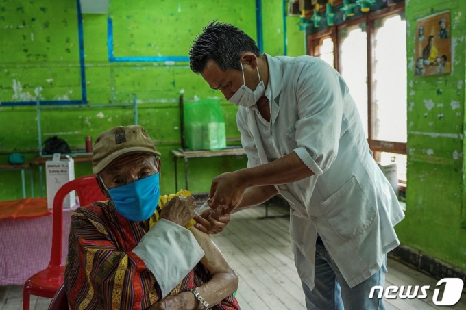 20일(현지시간) 부탄의 수도 팀부에 마련된 코로나19 백신 접종 센터에서 노인이 백신을 맞고 있다.  /AFP=뉴스1  