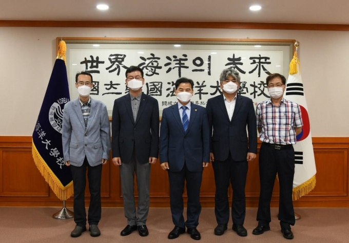 부산TP 김형균 원장(왼쪽에서 두 번째)이 한국해양대학교 도덕희 총장(가운데)과 지역사회 발전 협력방안을 논의하고 기념촬영을 하고 있다./사진제공=부산테크노파크