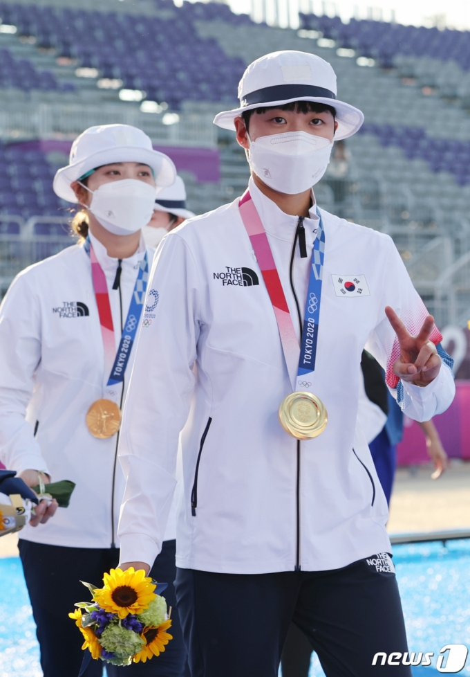 양궁 안산이 25일 일본 도쿄 유메노시마 공원 양궁장에서 열린 2020 도쿄올림픽 양궁 여자단체전 시상식에서 금메달을 목에 걸고 '브이'를 표시하고 있다.  한국 여자 양궁팀은 올림픽 단체전 9연패라는 대기록을 세웠다 /사진=뉴스1   